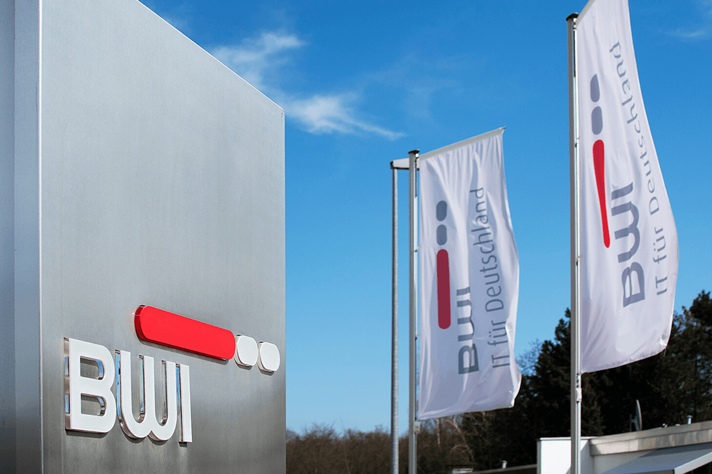Blick das Firmenschild und Fahnen der BWI GmbH vor der Firmenzentrale in Meckenheim.