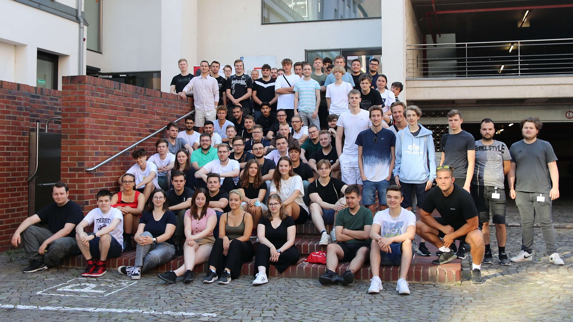 Gruppenbild mit 85 neuen BWI-Auszubildenden vor dem Stufenturm der Auermühle in Bonn