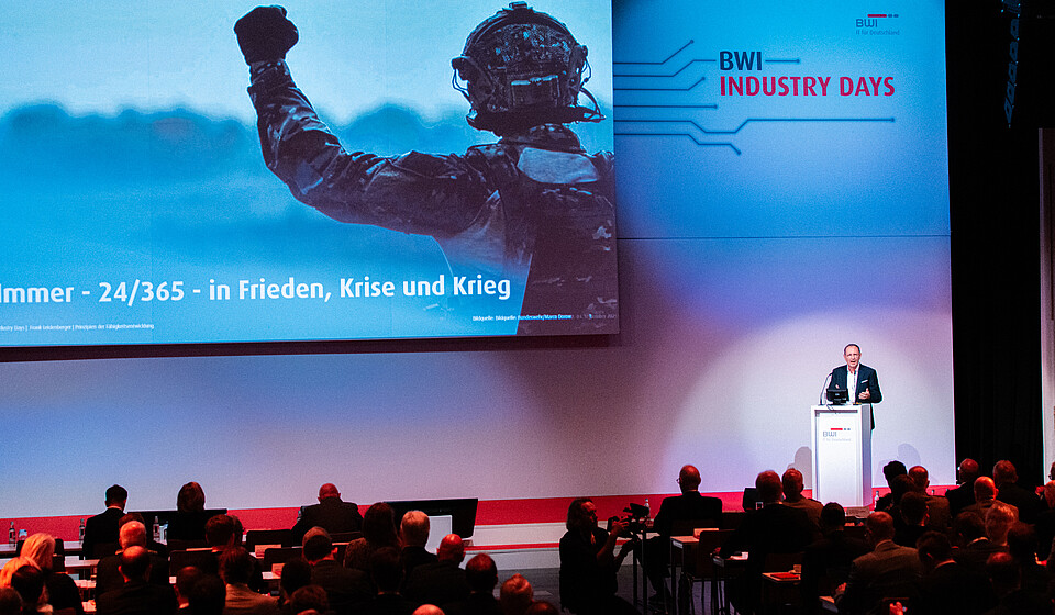 Frank Leidenberger, Chief Executive Officer der BWI, spricht auf einer Bühne im Kosmos Berlin vor über 600 Teilnehmenden