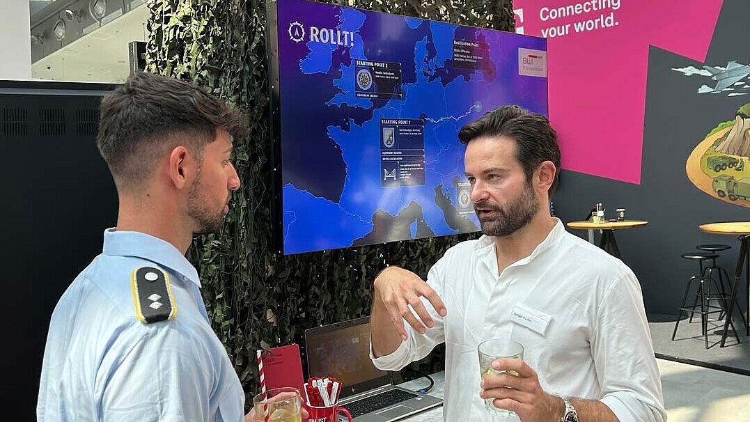 Mitarbeiter gibt Einblicke in das Innovationsexperiment ROLLT! zur Optimierung der Routenplanung und Navigation am BWI Messestand