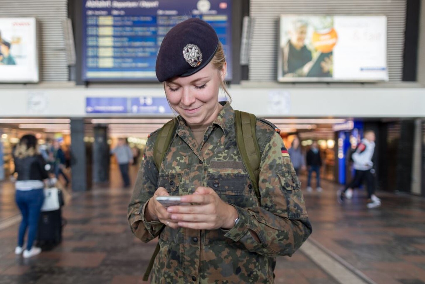 Soldatin, die auf ihr Handy schaut und sich im Bahnhof befindet © Bundeswehr/Jonas Weber
