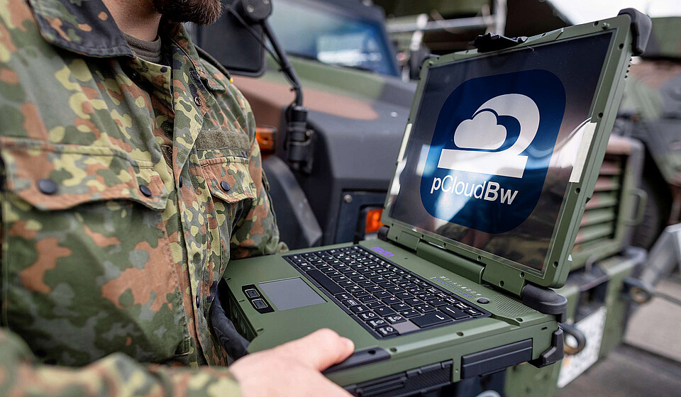 Soldat hat Bildschirm vor sich, auf diesem ist das pCloud Logo.