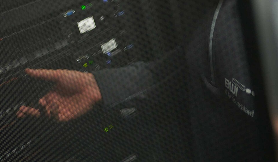 BWI-Mitarbeiter in einem Rechenzentrum vor einem Serverrack