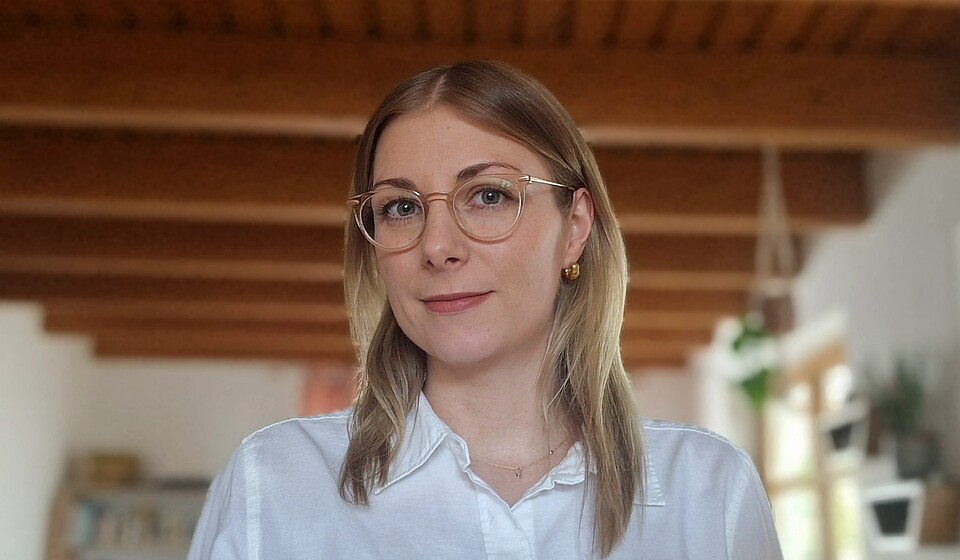 Junge Frau mit Brille schaut in die Kamera