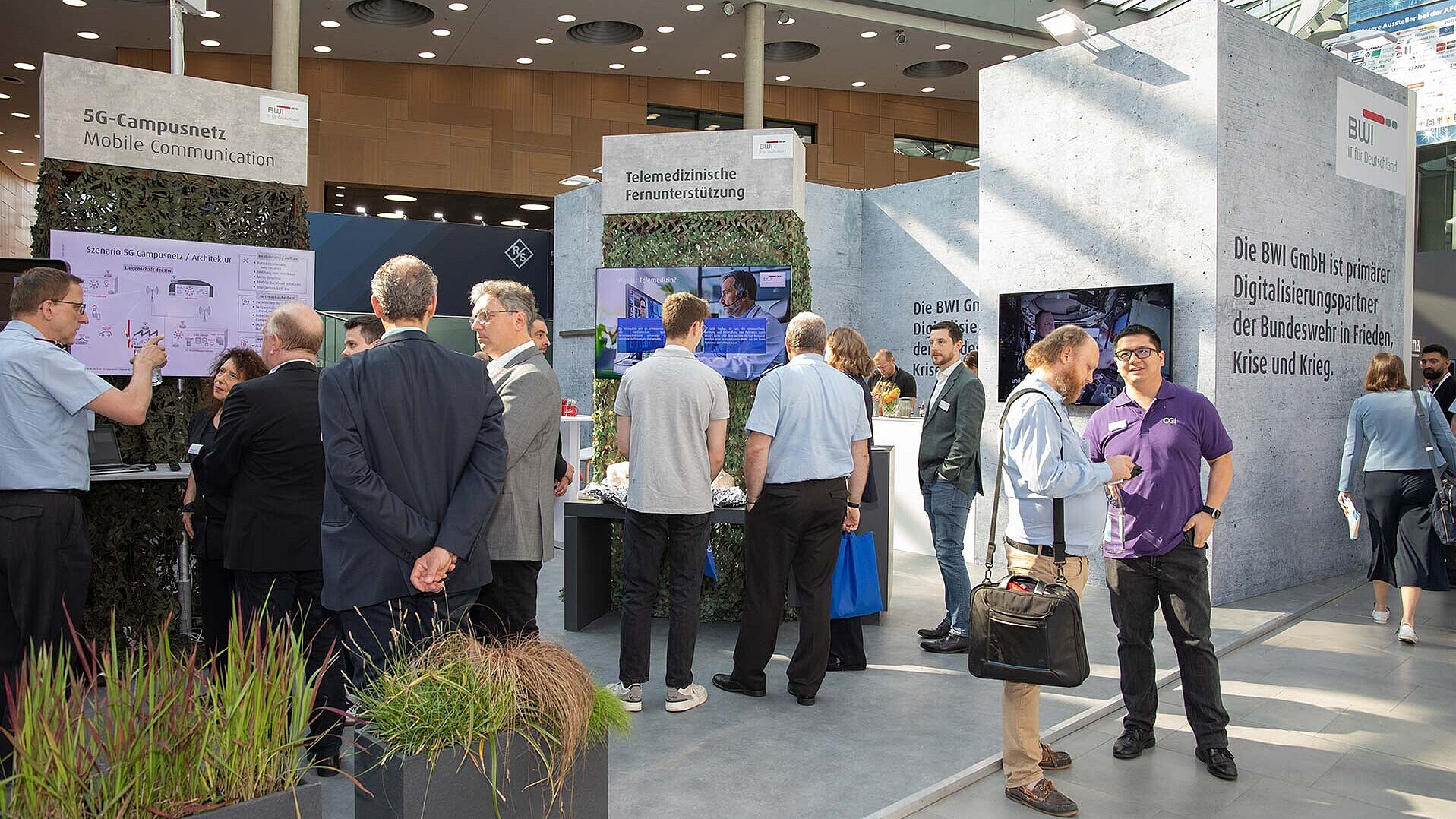 Blick auf den Stand der BWI mit zahlreichen Besucherinnen und Besuchern auf der AFCEA Fachausstellung 2024