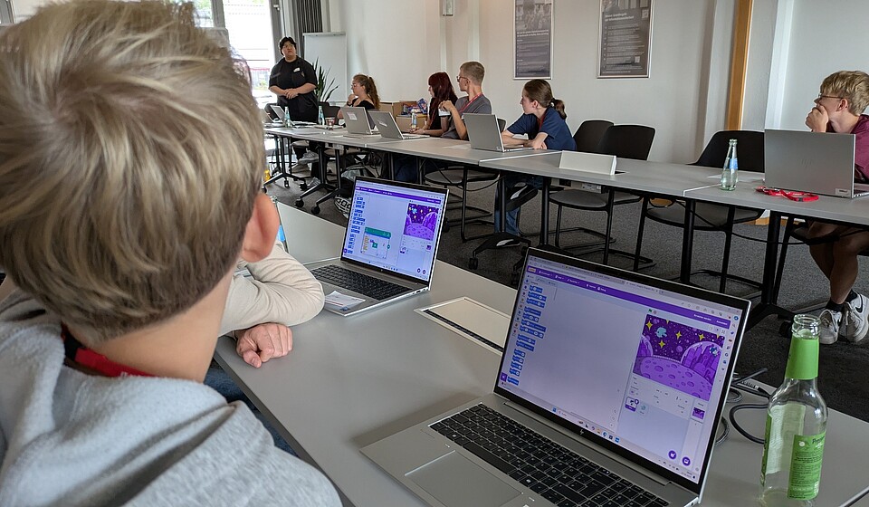 Junge sitzt vor Laptop