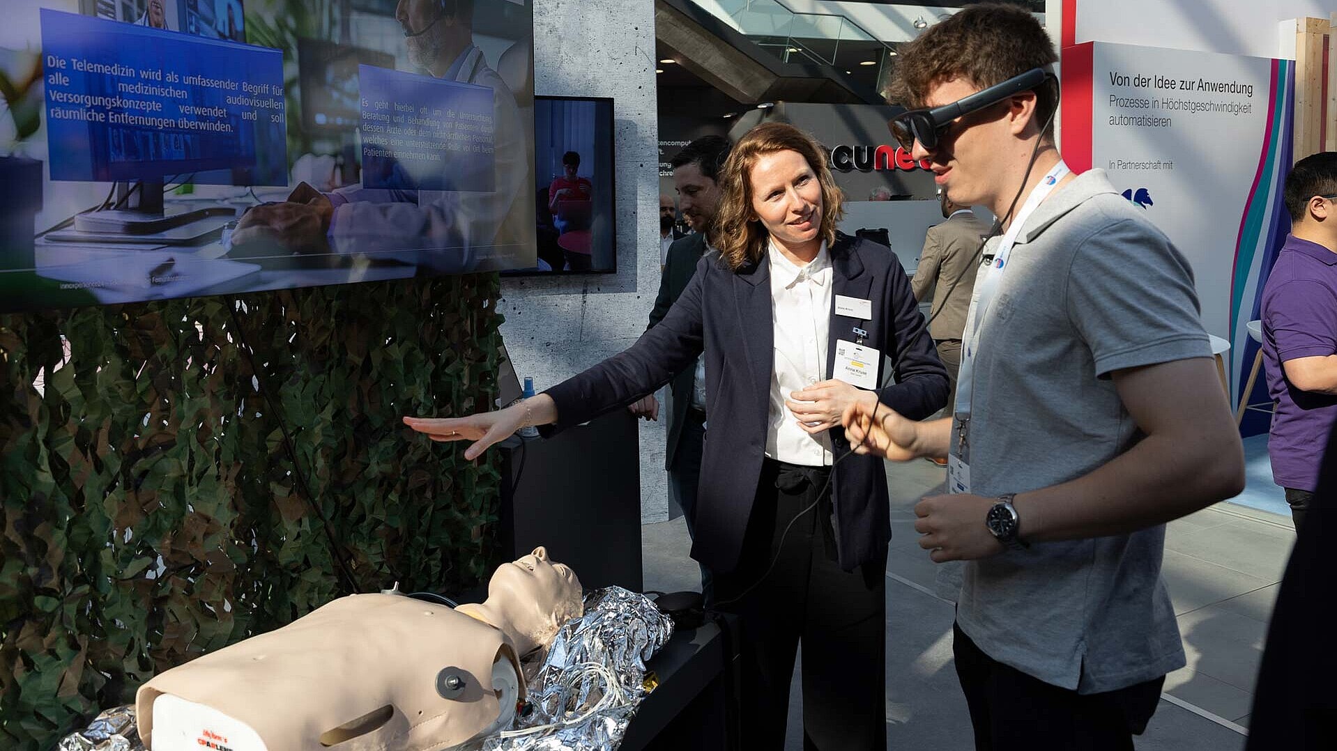 Besucher der AFCEA Fachausstellung 2024 trägt XR-Brille und testet die Telemedizinische Fernunterstützung 