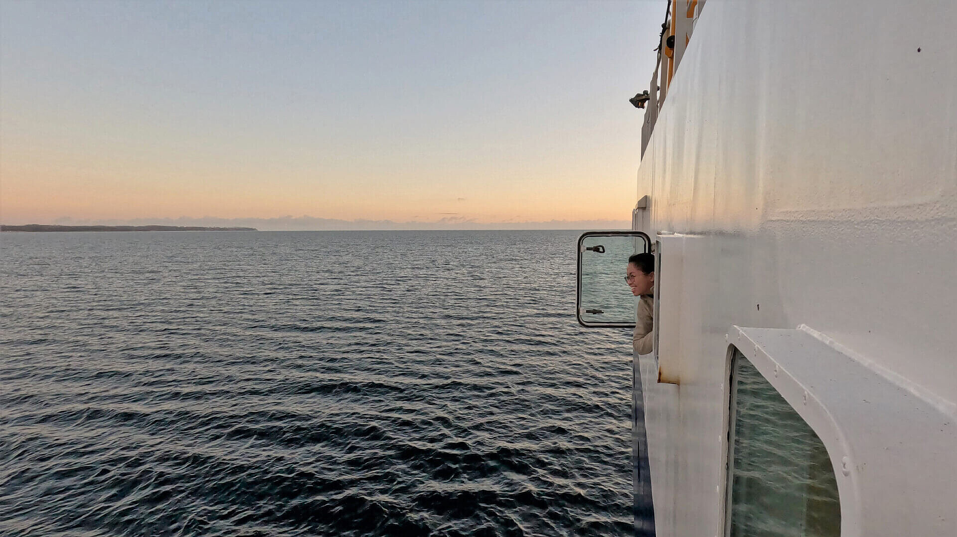 Eileen genießt den Blick auf die Ostsee durch ein Schiffsfenster..