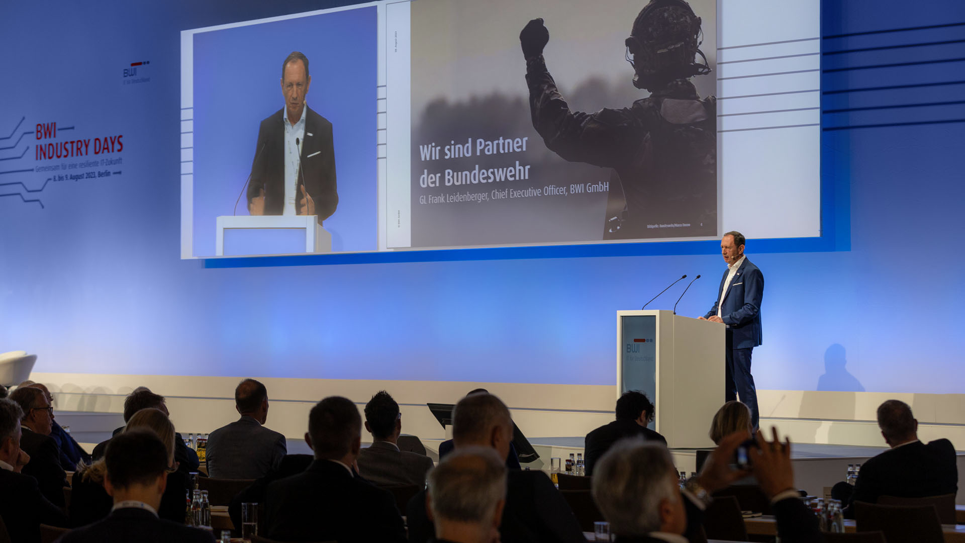 Frank Leidenberger, CEO der BWI GmbH, eröffnete die BWI Industry Days in Berlin. Foto von Leidenberger am Rednerpult. 