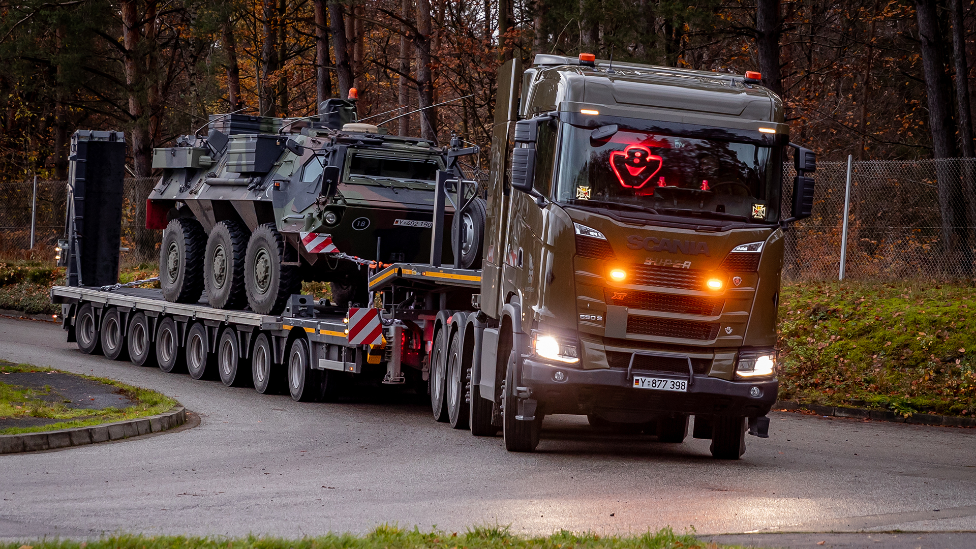 Lastwagen transportiert militärisches Fahrzeug zu seinem Einsatzort.