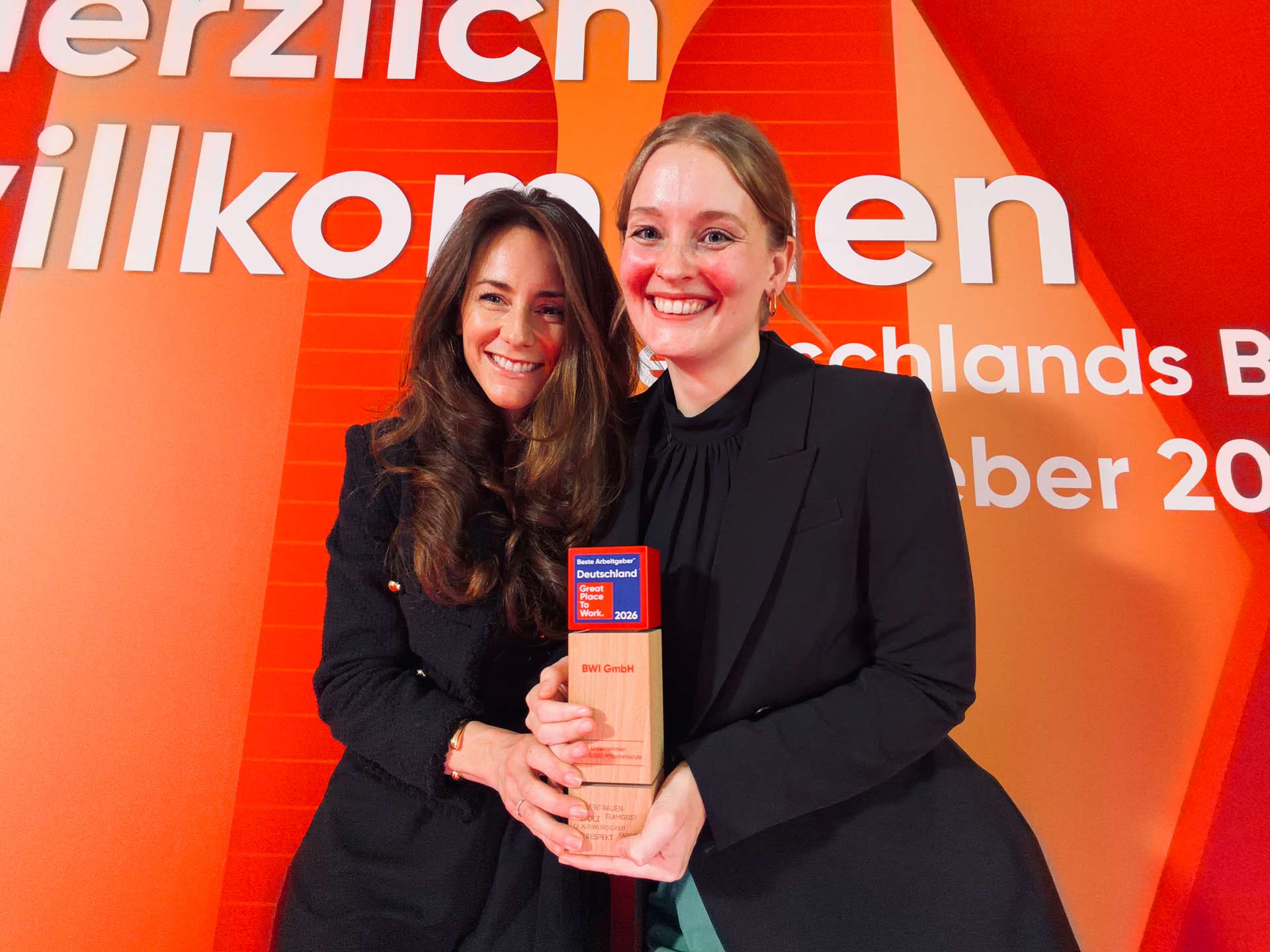 Zwei Mitarbeiterinnen nehmen die Auszeichnung entgegen.