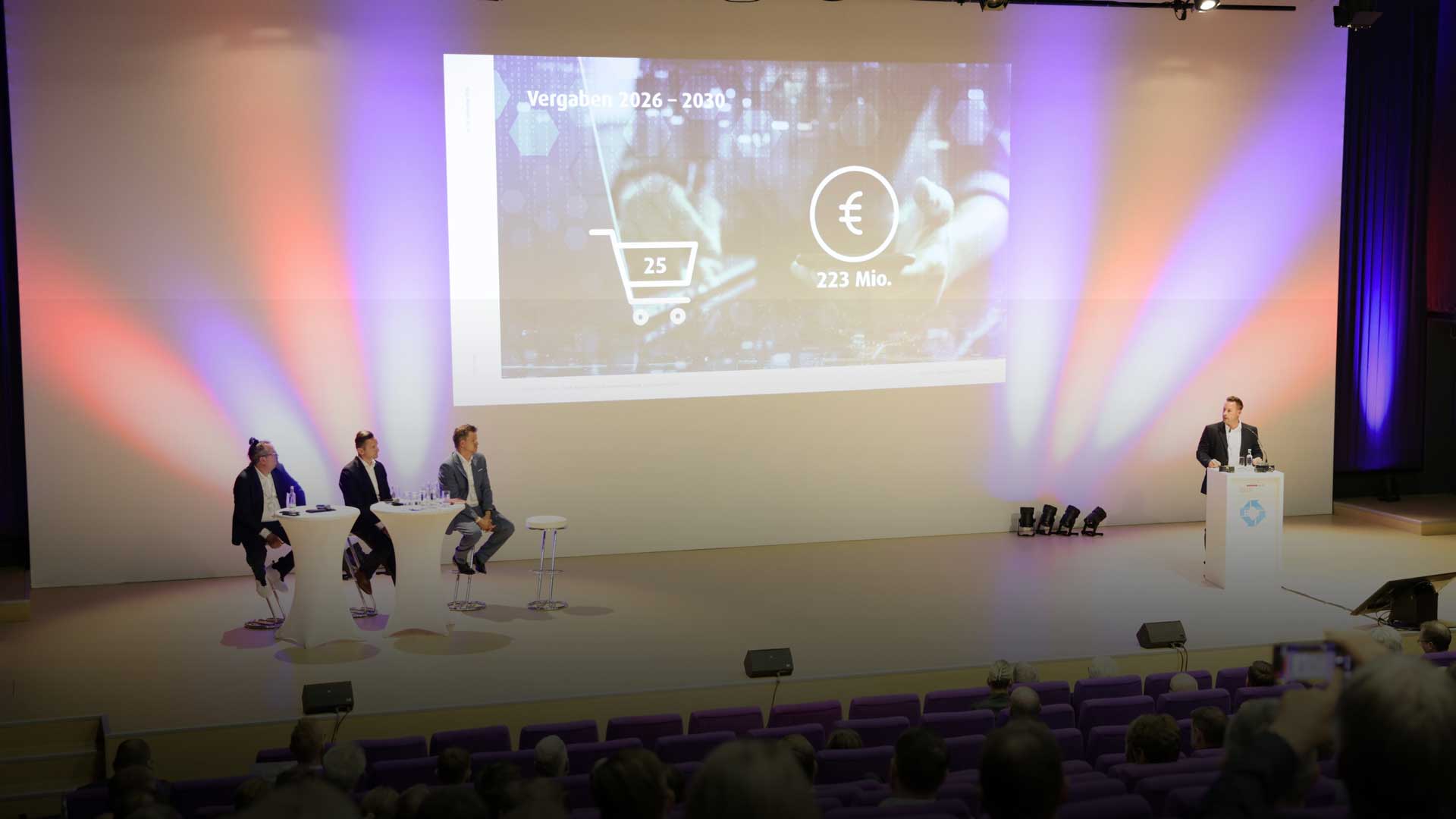 Bild von der Bühne auf den IndustryDays mit Folie zu den Vergabezeiträumen