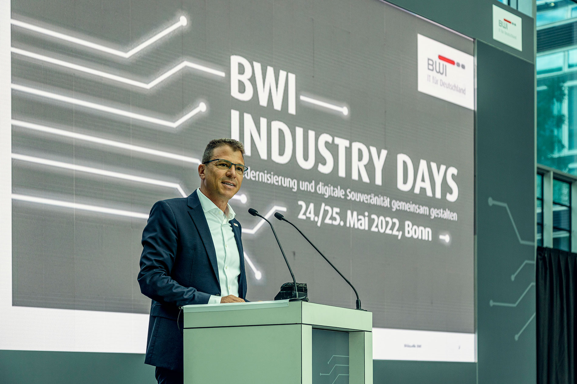 Martin Kaloudis am Rednerpult vor der BWI Industry Leinwand