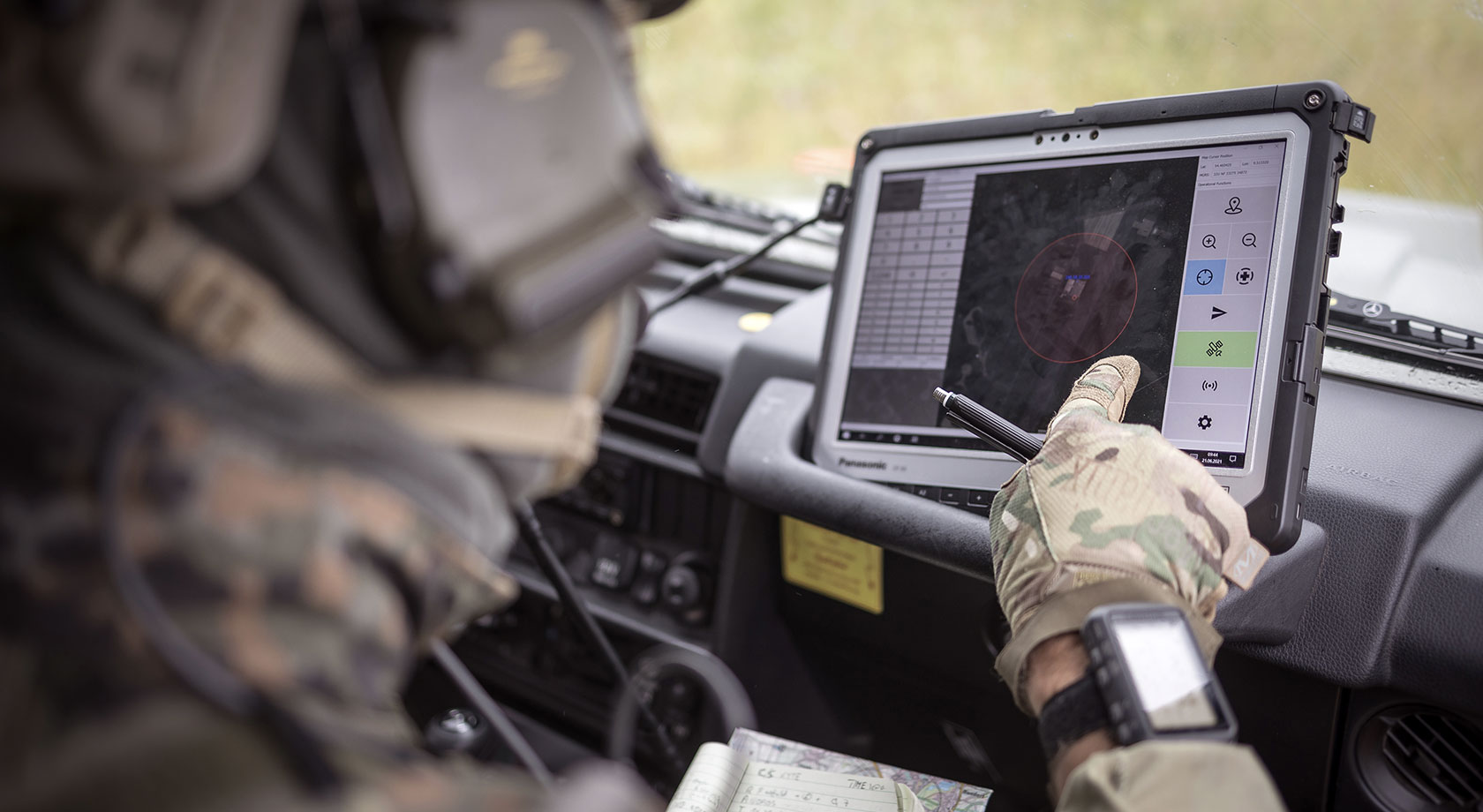 Ein Soldat sitzt in einem Fahrzeug und bedient einen Steuerungsmonitor.