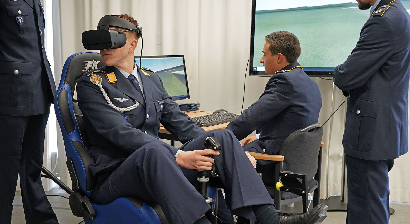 Vier Soldaten in einem Raum testen eine VR-Brille und ihre Anwendung.